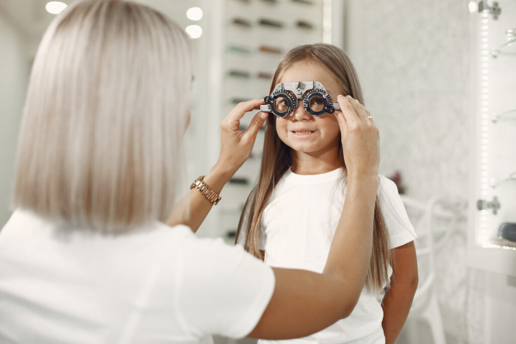 child eye test eye exam little girl having eye check up with phoropter doctor performs eye test child Central de Consultas | Clínica Popular