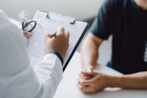 doctor holding test results consulting patient desk medical office hospital clinic healthcare professionalism concept Central de Consultas | Clínica Popular