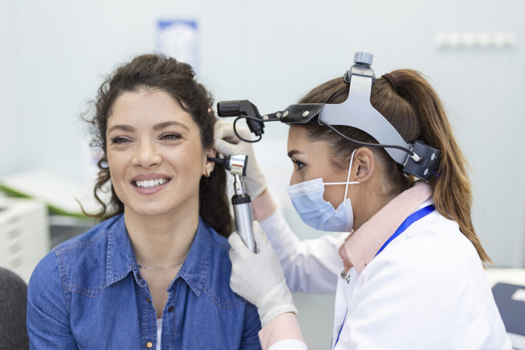 hearing exam otolaryngologist doctor checking woman s ear using otoscope auriscope medical clinic Central de Consultas | Clínica Popular