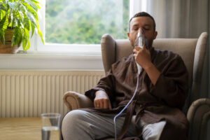 front view man using nebulizer Central de Consultas | Clínica Popular