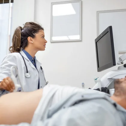 careful-female-doctor-white-coat-sitting-front-ultrasound-apparatus-conducting-abdominal-diagnostics-with-transducer (1)